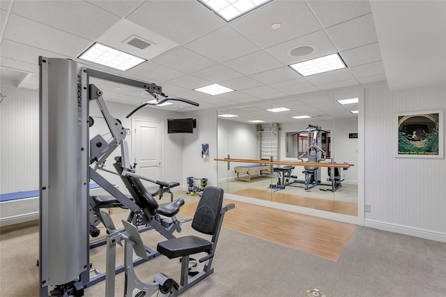 exercise room featuring a paneled ceiling and light hardwood / wood-style floors