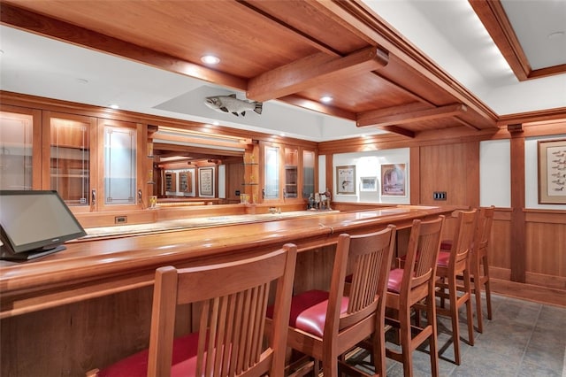 bar featuring beamed ceiling, wood counters, wood ceiling, and wooden walls