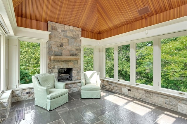 unfurnished sunroom with a fireplace, plenty of natural light, and wooden ceiling