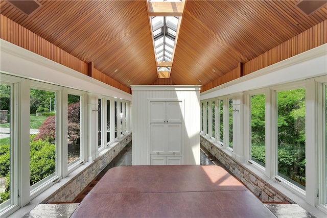 unfurnished sunroom featuring vaulted ceiling with skylight