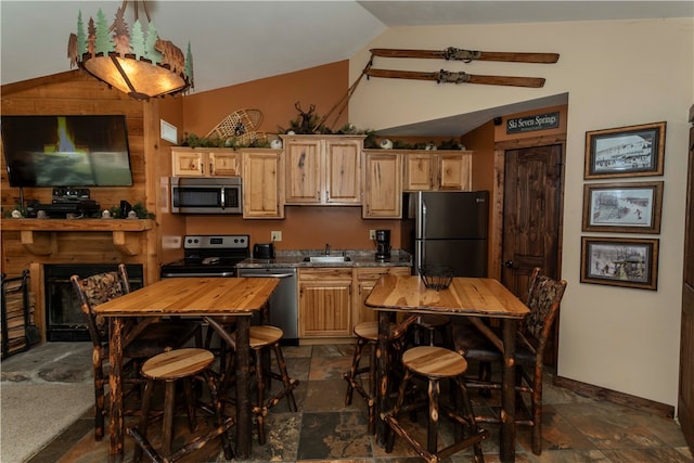 kitchen featuring wood counters, light brown cabinets, lofted ceiling, sink, and stainless steel appliances