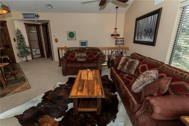 carpeted living room with ceiling fan and vaulted ceiling