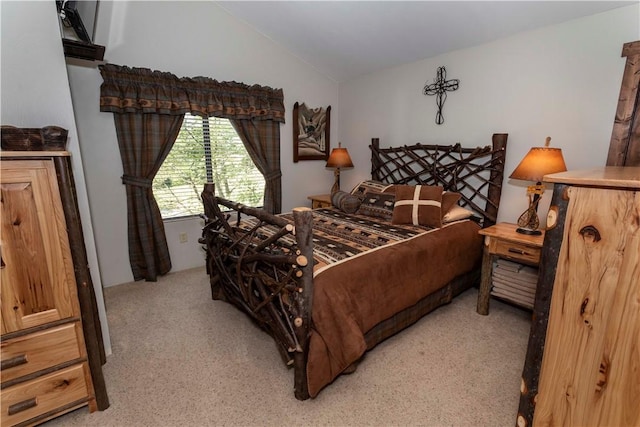 bedroom with vaulted ceiling and light colored carpet