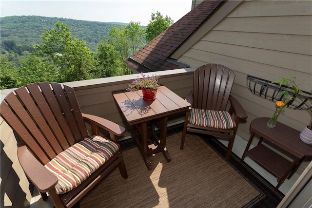 balcony featuring a wooded view