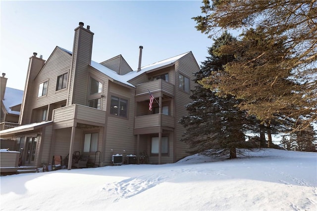 exterior space with central air condition unit and a chimney