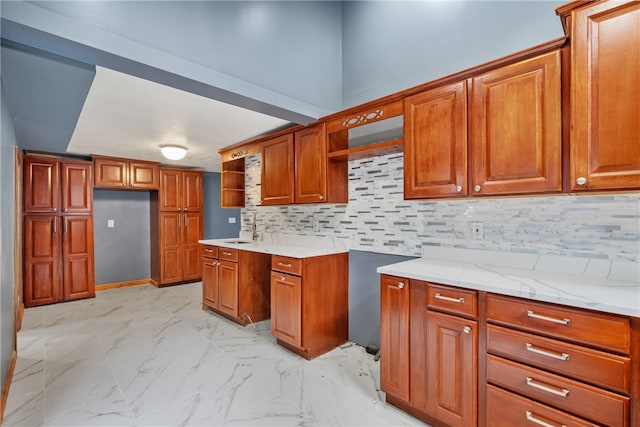 kitchen with sink, tasteful backsplash, light stone counters, and light tile flooring