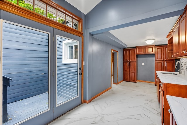 kitchen featuring sink, light stone countertops, and light tile flooring