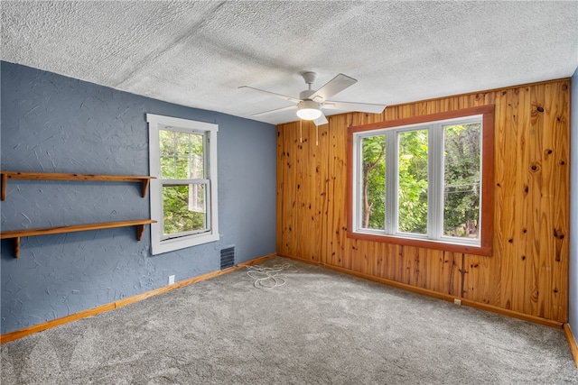 carpeted empty room featuring a textured ceiling and ceiling fan