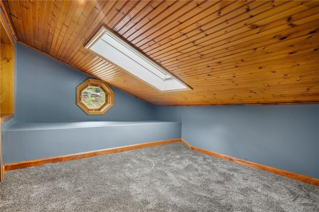 additional living space with wooden ceiling, carpet, and vaulted ceiling with skylight