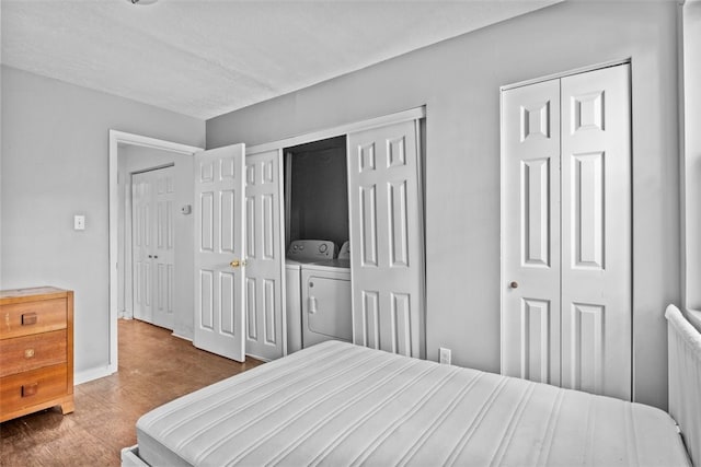 bedroom with multiple closets, hardwood / wood-style flooring, and independent washer and dryer