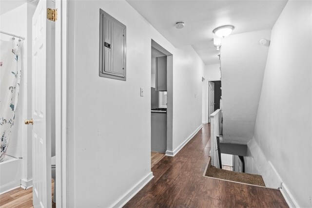 corridor with dark hardwood / wood-style floors and electric panel