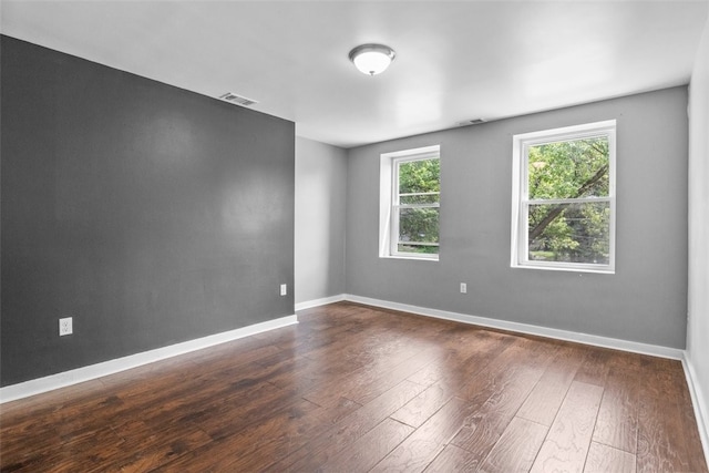 empty room with dark hardwood / wood-style flooring