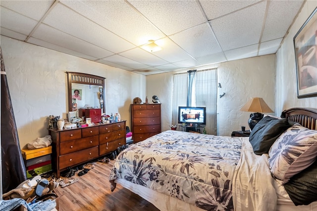 bedroom featuring hardwood / wood-style flooring and a drop ceiling