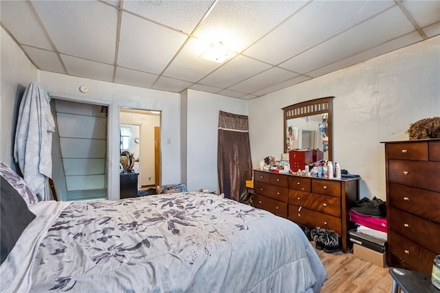 bedroom with light hardwood / wood-style floors and a drop ceiling