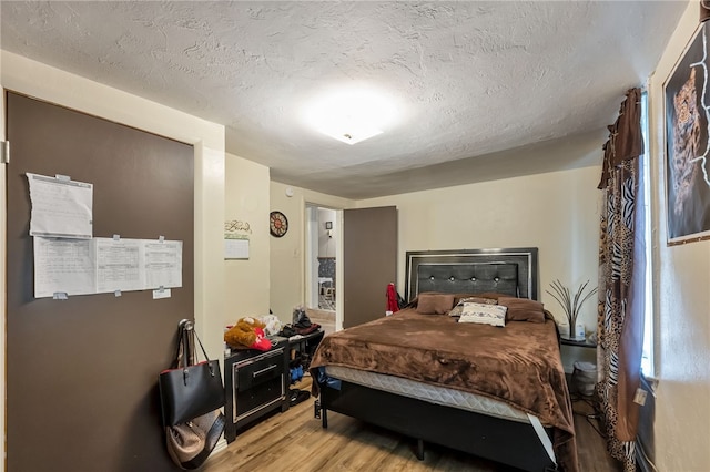 bedroom with hardwood / wood-style flooring and a textured ceiling