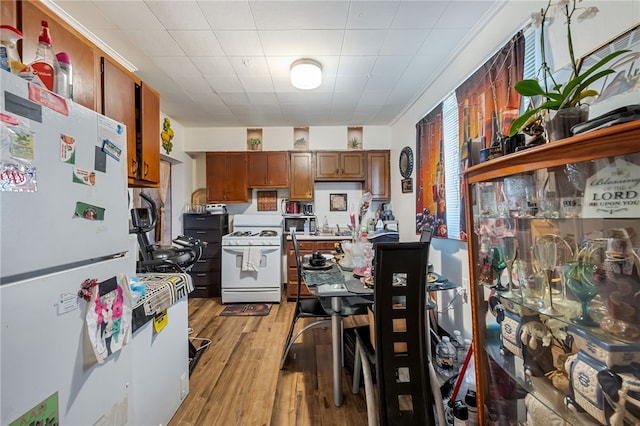 kitchen featuring white appliances and light hardwood / wood-style flooring