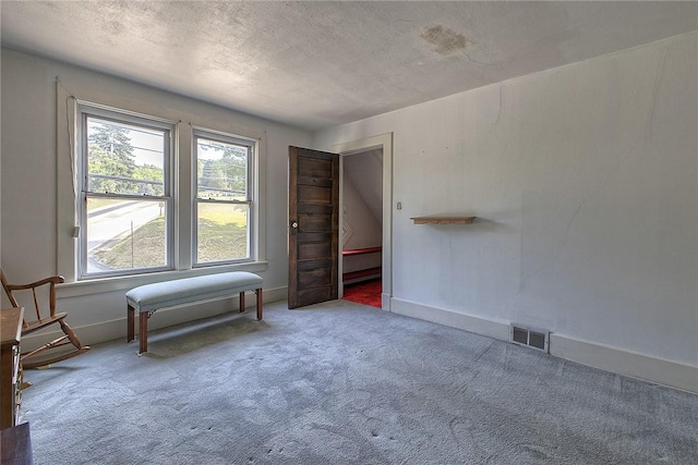 unfurnished room featuring carpet and a textured ceiling