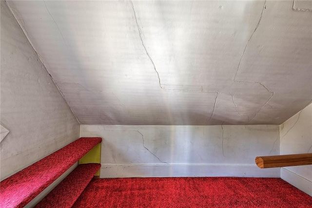 additional living space featuring lofted ceiling and carpet flooring