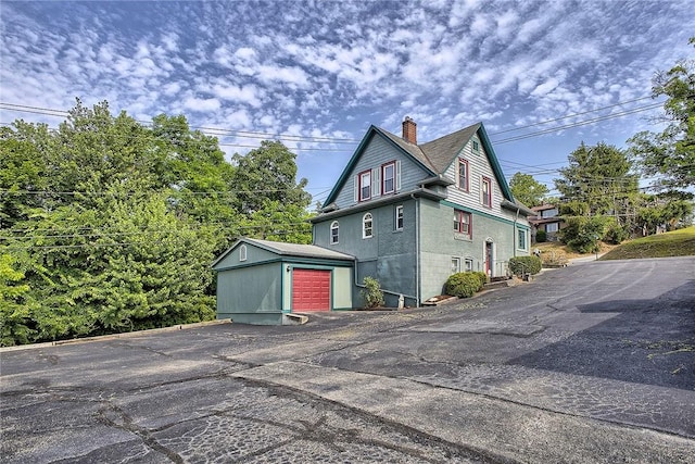 view of property exterior featuring a garage and an outdoor structure