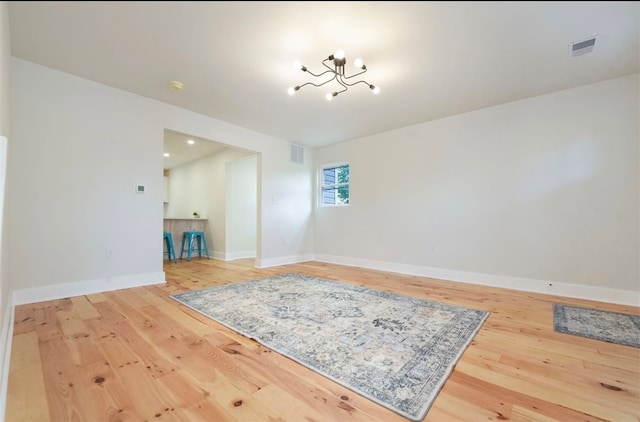 spare room featuring visible vents, baseboards, and wood-type flooring