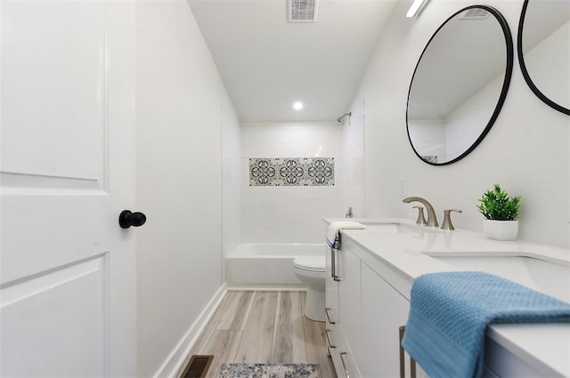 bathroom featuring vanity, toilet, wood finished floors, and visible vents