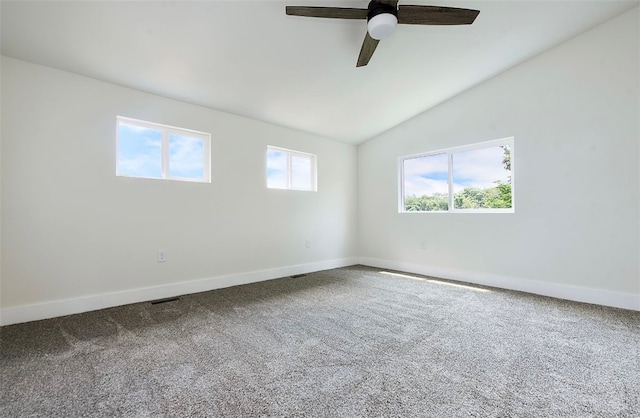 unfurnished room with plenty of natural light, ceiling fan, carpet floors, and vaulted ceiling