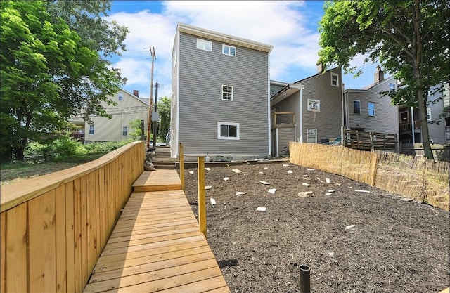 rear view of property featuring fence