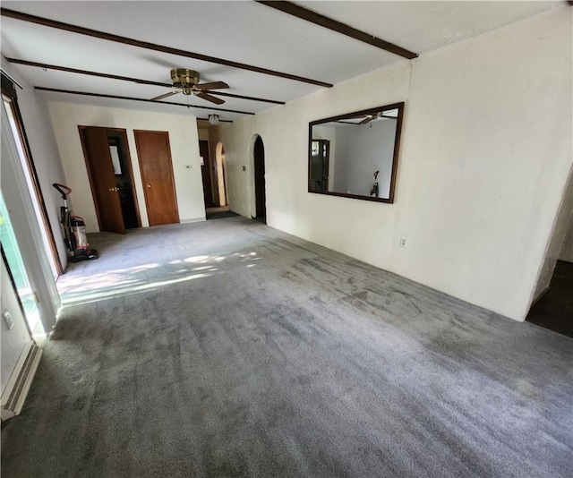 carpeted empty room with ceiling fan and beamed ceiling