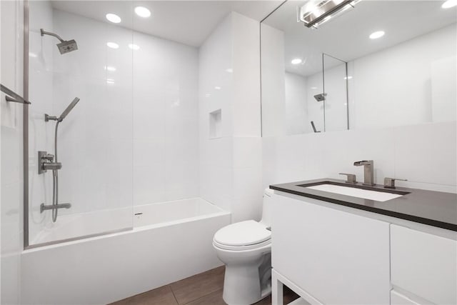 full bathroom with tiled shower / bath, tile patterned flooring, vanity, and toilet