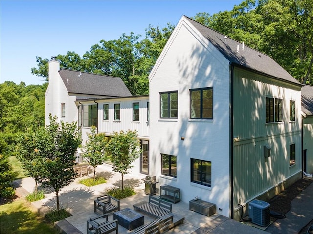 rear view of house with central air condition unit and a patio