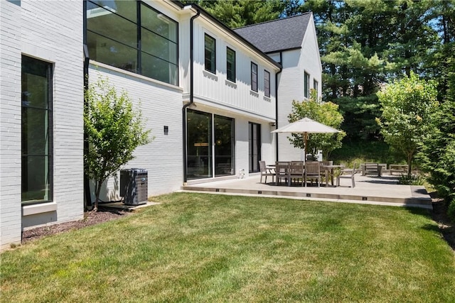 back of property featuring central AC, a patio area, and a yard