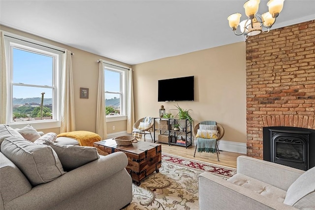 living room with a chandelier, a mountain view, hardwood / wood-style flooring, and a brick fireplace