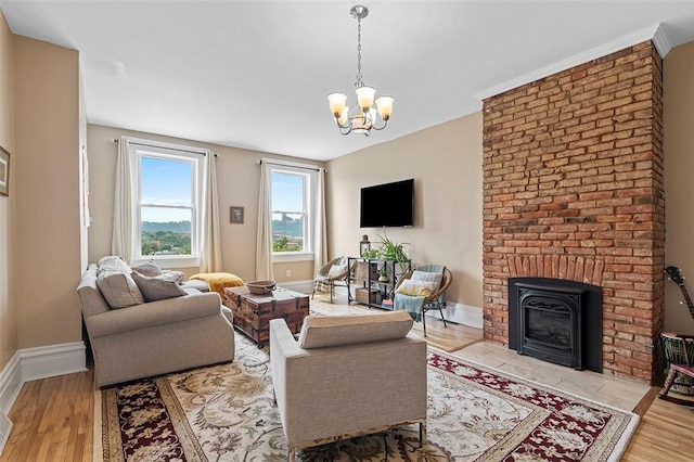 living room featuring an inviting chandelier, a fireplace, and light hardwood / wood-style flooring