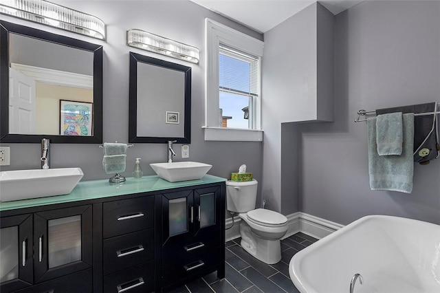 bathroom with tile patterned floors, vanity, toilet, and a bathing tub