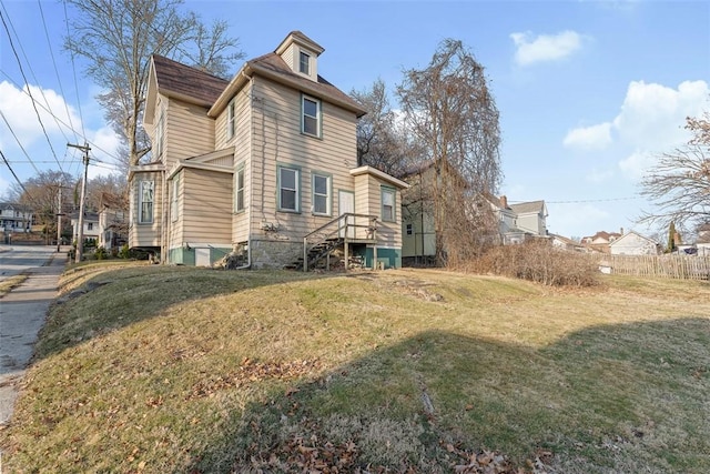 exterior space with a residential view, a lawn, and fence