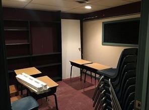 carpeted office space featuring a paneled ceiling