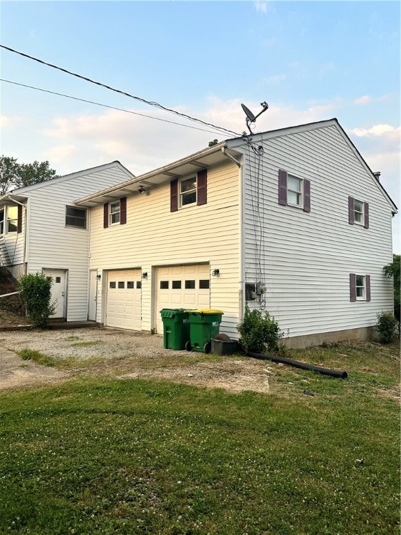 view of side of home featuring a garage and a lawn