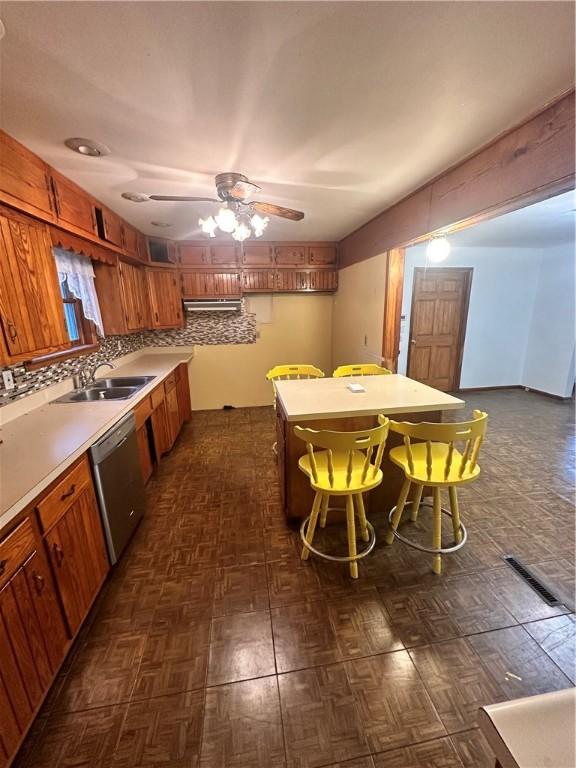 kitchen featuring backsplash, sink, ceiling fan, and stainless steel dishwasher