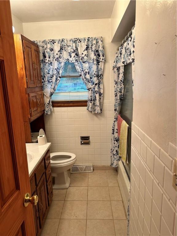 bathroom featuring tile walls, toilet, tile floors, and vanity