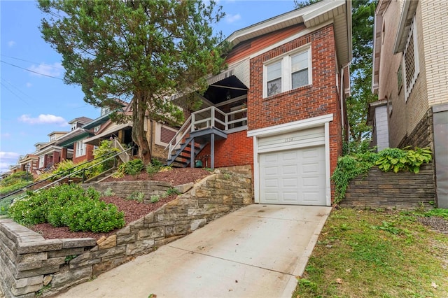 view of front of house with an attached garage, driveway, stairs, and brick siding