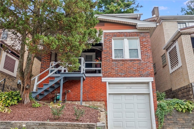 view of front of house with brick siding, an attached garage, and stairs