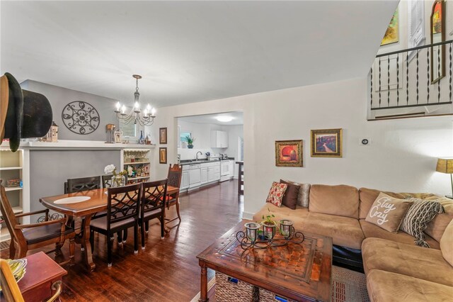 living room featuring sink, a notable chandelier, and dark hardwood / wood-style floors