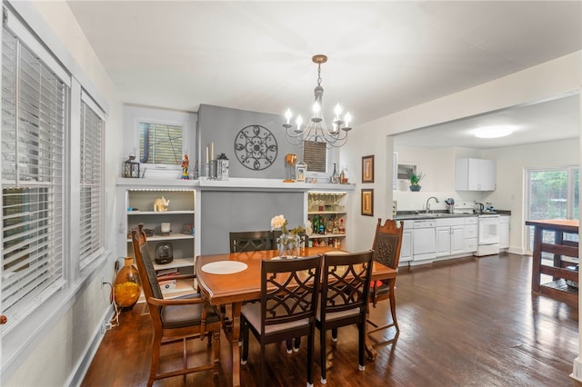 dining room featuring dark wood-type flooring, sink, and a chandelier