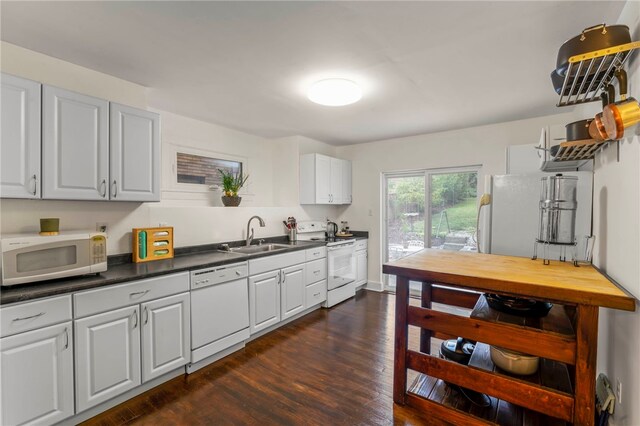 kitchen with sink, white cabinets, dark wood-type flooring, and white appliances