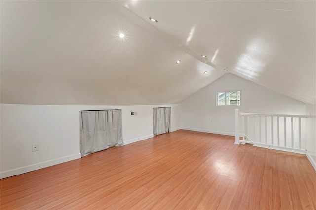 additional living space with lofted ceiling and light wood-type flooring