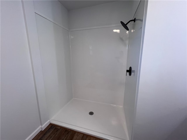 bathroom featuring hardwood / wood-style flooring and walk in shower