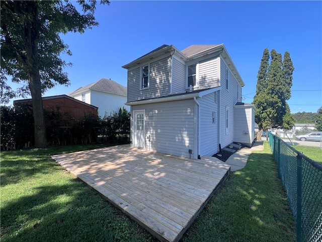 back of property with a wooden deck and a yard