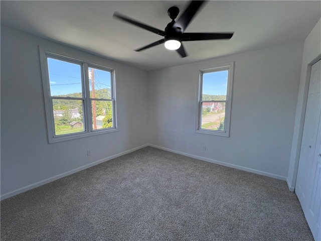 carpeted spare room with ceiling fan and a healthy amount of sunlight