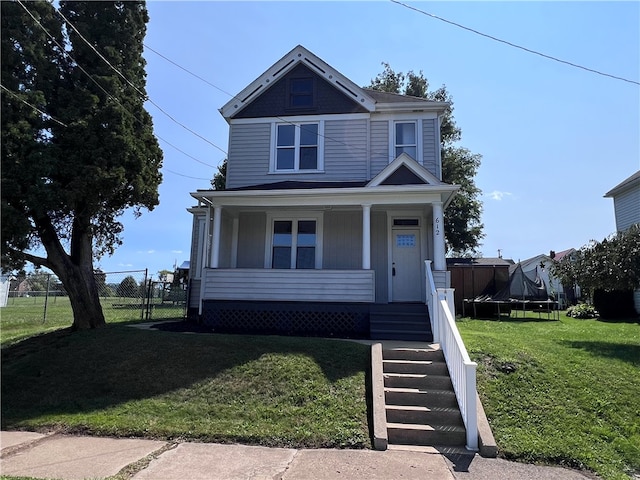 view of front of home featuring a trampoline, a front lawn, and a porch