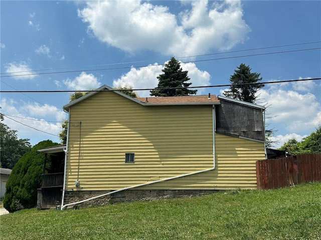 view of side of home with a yard